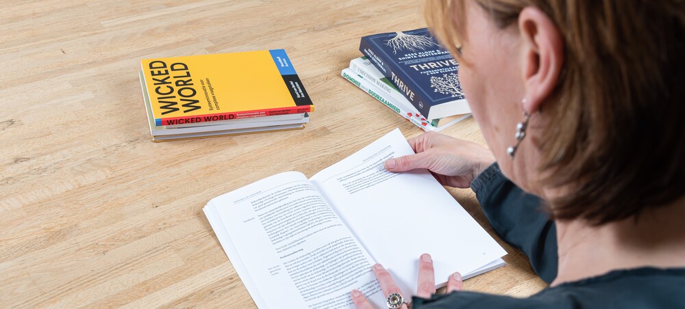 Verdiepen in strategie_DSC2193 Adviseur bestudeert boeken als wicked world en thrive.