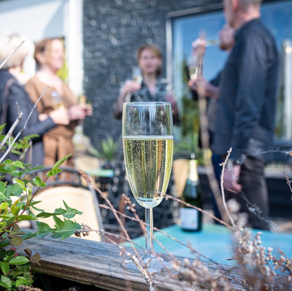 champagneglas met proostende ondernemers en adviseur voor aankoop bedrijf